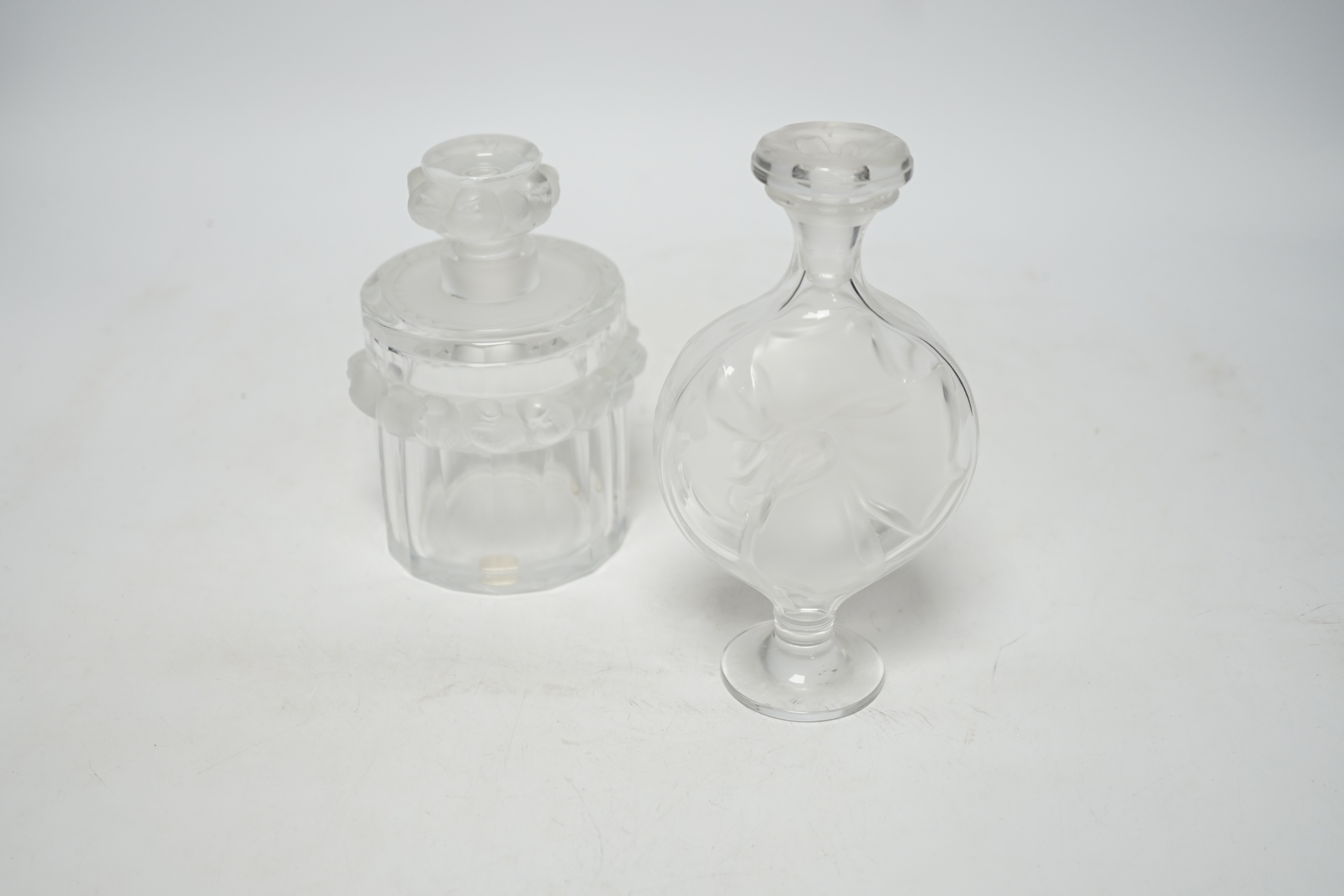 Two Lalique glass scent bottles and stoppers comprising ‘Robinson’ and ‘Moulin Rouge’, signed to the bases, largest 17cm high